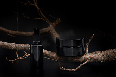 黑色无品牌化妆品霜罐和带有树枝的血清。