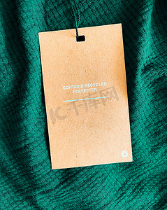 衣服平铺摄影照片_包含再生聚酯时尚标签、豪华翠绿色面料背景的销售价格卡、购物和零售