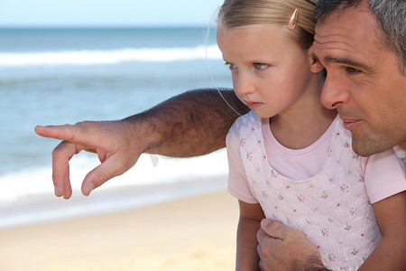父亲和年幼的女儿在海滩上