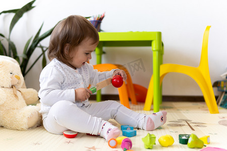 快乐有趣的孩子卷发女婴与​​教育玩具块花。