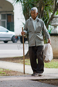 拄着拐杖的老人摄影照片_拄着拐杖的老人