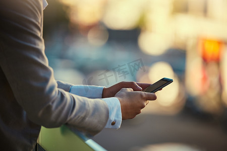 商人在户外手机上打字，在城市散景中在线交流、阅读和发短信。