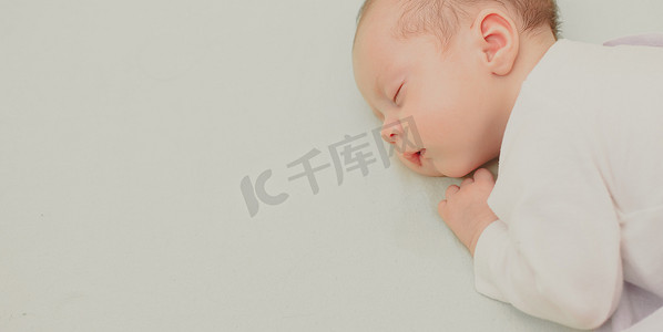 婴儿摄影照片_婴儿睡在复制空间婴儿床上。