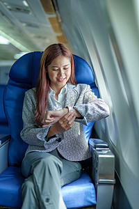 一位微笑的亚洲女商人看着飞机上的时间的肖像