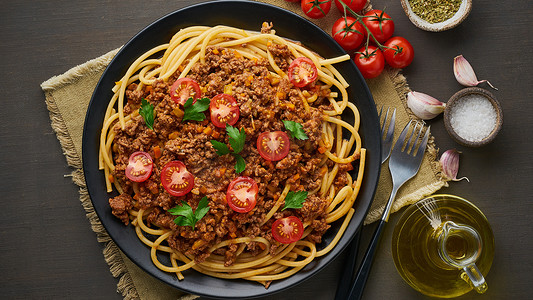 意大利面肉酱布卡蒂尼，配肉末和西红柿，深色木质背景，顶视图，横幅长