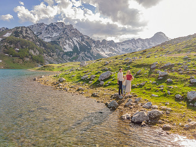黑山美丽的杜米托尔国家公园的山湖景观中，有湖冰川和反射山的游客妈妈、爸爸和儿子的家庭
