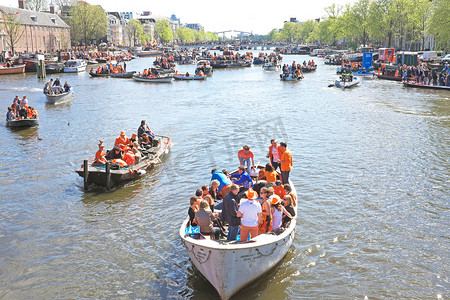 王者出征摄影照片_4 月 27 日：阿姆斯特丹运河上挤满了橙色杜的船只和人