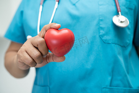 治愈者摄影照片_医生在医院病房抱着一颗红心，健康强大的医疗理念。
