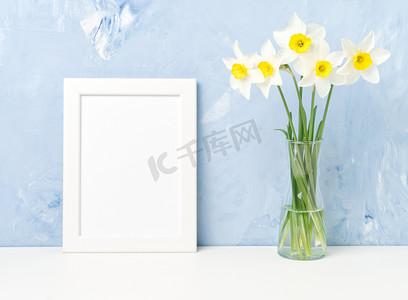 鲜花花束，桌上的白色框架，对面的蓝色纹理混凝土墙