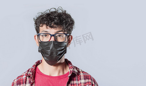 孤立背景下戴着手术口罩的男人的特写，戴着防护面具的帅哥的特写
