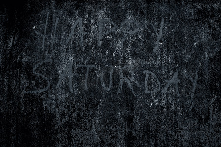 快乐星期六用蓝色粉笔在粗糙的墙上写下，特写水平镜头。