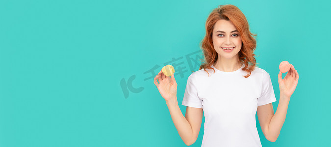 幸福的女人在蓝色背景上拿着甜甜的马卡龙法式饼干。