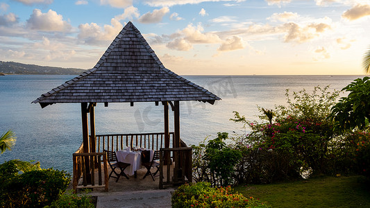 海边酒店摄影照片_日落时的餐桌，浪漫的海边晚餐，欣赏美丽的加勒比海