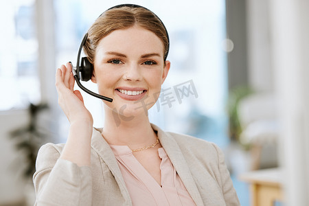 微笑、友好的呼叫中心代理，戴着耳机，在 IT 技术机构进行在线咨询。