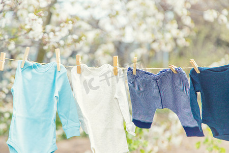 洗衣服男孩摄影照片_街上正在晾晒婴儿的衣服。