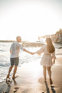一对热恋中的情侣正在海边的沙滩上散步。
