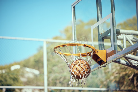 篮球场、运动和球或环网，反对外面的蓝天。