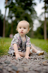 悲伤的女婴坐在石头巷子上