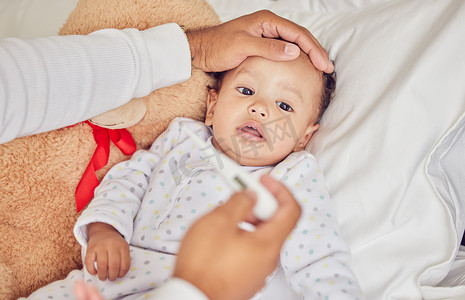 宝宝得了新冠肺炎，发烧了，孩子的父母躺在家里卧室的床上，身上有一个身体不适的孩子的父母给的体温计。