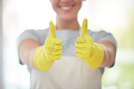 一名面目全非的家政工人戴着手套清洁时竖起大拇指。