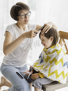 剪头发摄影照片_妈妈亲自给儿子剪头发。