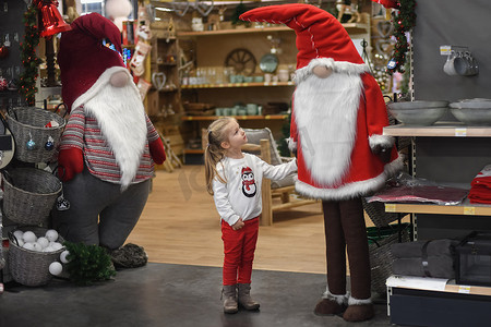 女孩在一家有装饰品的商店里看着圣诞老人