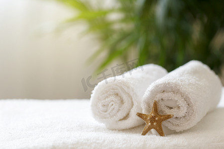 浴室打扫摄影照片_酒店房间床上铺着卷白毛巾