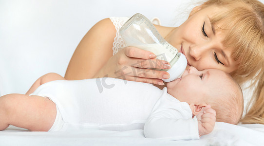 母亲用奶瓶喂养婴儿。