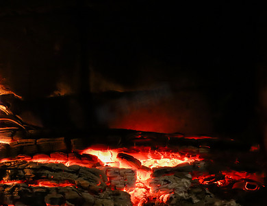黑色背景的壁炉里烧着的木头的热煤。