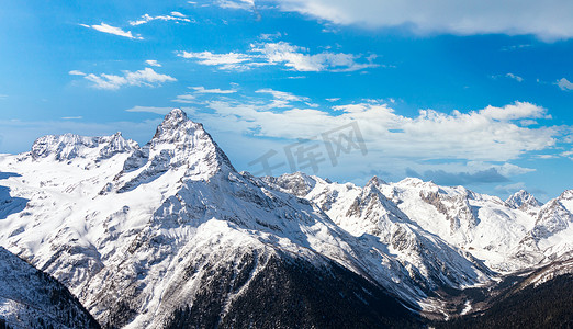 山峰背景图摄影照片_冬天的山峰被白雪覆盖。