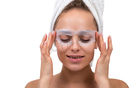有魅力的女人洗完澡后，脸上戴着化妆品布面膜，保护眼睛周围的皮肤