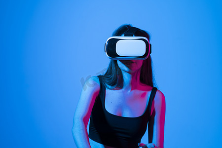 年轻的黑发女性戴着 VR 眼镜，在虚拟模拟世界中工作。