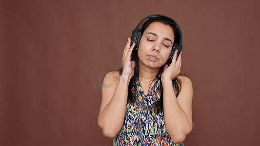印度女人戴着耳机听音乐很开心