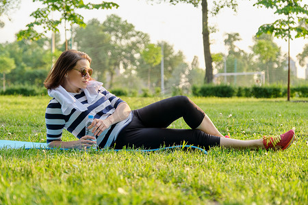 公园垫子上健身锻炼后休息的成熟女性