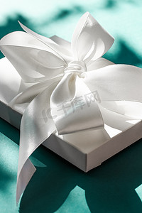 翠绿背景上带丝带和蝴蝶结的豪华假日白色礼盒、豪华婚礼或生日礼物