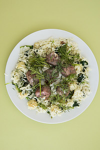 瑞典肉丸配莳萝，上面撒上芹菜和菠菜米饭。