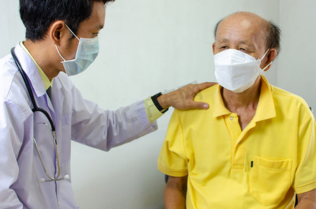 医生扶着他的肩膀，对生病的老人说话给予鼓励。