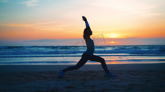 剪影女人练习瑜伽战士姿势冥想与暑假海滩幸福和放松。