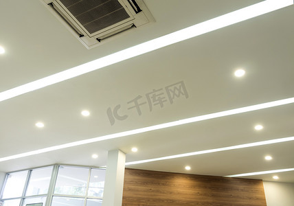 现代办公室天花板上的照明和天花板安装空调