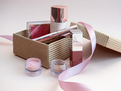 一套用于女性面部和眼部化妆的化妆品，装在粉红色背景的棕色工艺盒中。