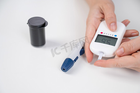 妇女用血糖仪测量血糖水平。