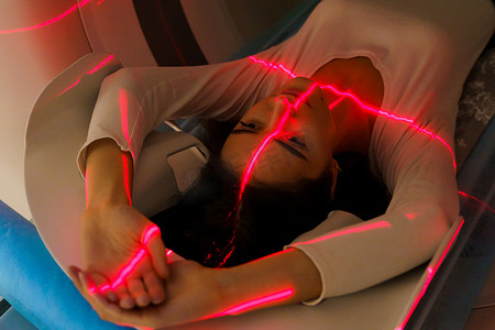 阑尾炎摄影照片_红色射线对女孩进行计算机断层扫描 腹部 CT 扫描为女性治疗阑尾炎、肿瘤、囊肿、腹主动脉瘤