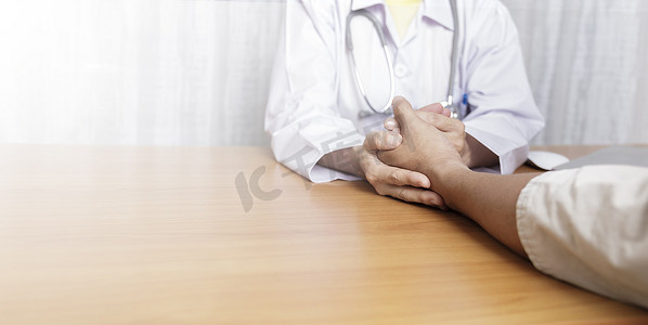 医生在她的诊所工作并倾听病人的心声，医生握住病人的手并倾听解释他的症状。