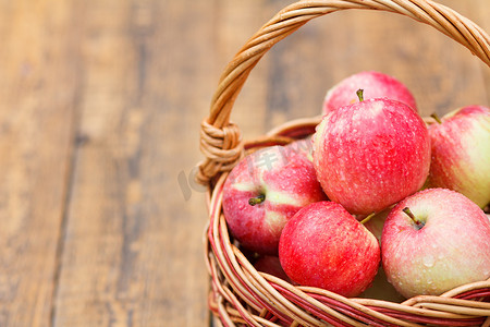 木板上柳条篮里的红苹果