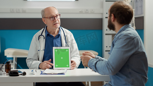 高级医生在办公室的数字平板电脑上显示绿屏