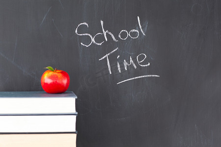 一摞书和孩子摄影照片_一摞书，上面有一个红苹果和一块黑板，上面写着“学校 ti”