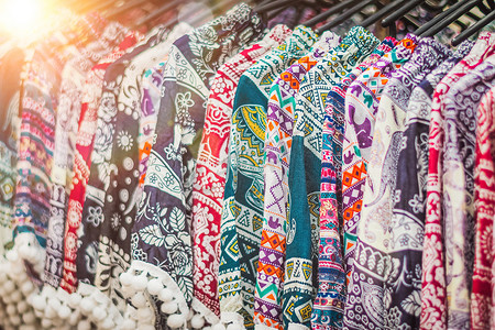 泰国跳蚤市场纪念品店架子上挂着的衣服