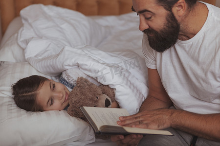 成熟的留着胡子的男人和他的小女儿在家休息