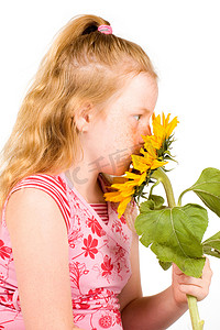 女孩正在闻一朵大向日葵的味道