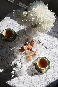 英式茶歇，早晨阳光下的静物画，鲜花和甜甜圈